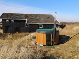uma casa com uma banheira de hidromassagem em frente a uma casa em Holiday Home Hansina - 500m from the sea in Western Jutland by Interhome em Fanø