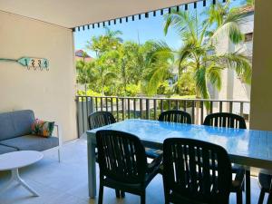 una mesa azul y sillas en un balcón con palmeras en 124 Hastings Street 2 bedroom walk to the beach, en Noosa Heads