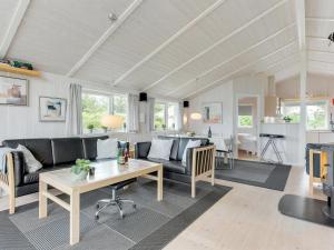 een woonkamer met een bank en een tafel bij Holiday Home Tjakko - 700m from the sea in SE Jutland by Interhome in Neder Lysabild