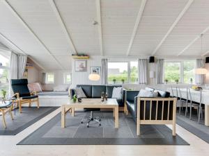 een woonkamer met een bank en een tafel bij Holiday Home Tjakko - 700m from the sea in SE Jutland by Interhome in Neder Lysabild