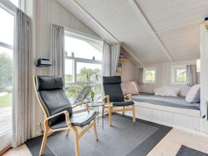 een kamer met 2 stoelen, een bed en een raam bij Holiday Home Tjakko - 700m from the sea in SE Jutland by Interhome in Neder Lysabild