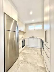 a large kitchen with a stainless steel refrigerator at 6Apt Beautifully renovated on Hastings Street in Noosa Heads