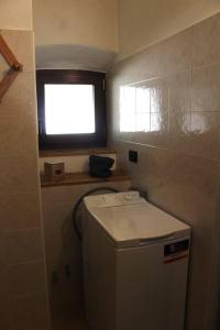 a small kitchen with a small window and a small refrigerator at Casa Griot in Pragelato