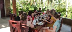 een groep mensen die aan een tafel zitten bij Rice Rice Villas in Tissamaharama