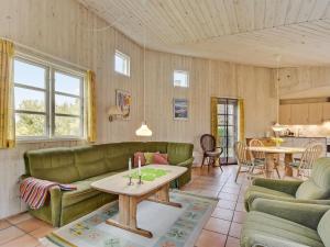 salon z zielonymi kanapami i stołem w obiekcie Holiday Home Alma - 400m from the sea in SE Jutland by Interhome w mieście Augustenborg