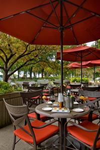 an outdoor restaurant with tables and chairs with red umbrellas at Hôtel Le Concorde Québec in Quebec City