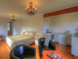 a bedroom with a bed and a table and chairs at Shearwater Scenic Villas in Burnt Pine