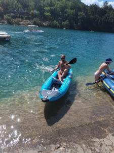 two men in a paddle boat on a lake at Chambre privée au cœur du Verdon in Saint-Julien