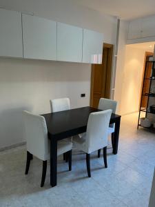una mesa negra y sillas blancas en una habitación en Red house in Monteverde - Zen Real Estate, en Roma
