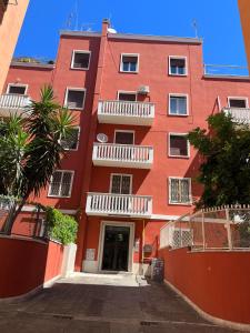 een rood gebouw met witte balkons in een straat bij Red house in Monteverde - Zen Real Estate in Rome