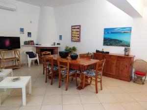 een eetkamer met een houten tafel en stoelen bij SanvitoTour - Le Terrazze in San Vito lo Capo
