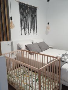 a crib in a bedroom with a bed at Torre de Ambroz in Plasencia