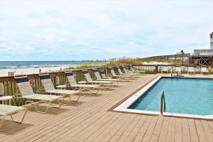 a row of chairs and a swimming pool on a beach at Broadmoor 304 in Orange Beach
