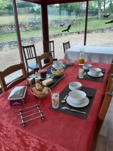 een tafel met een rode tafeldoek met eten erop bij Domaine Lagardelle Rocamadour in Rocamadour
