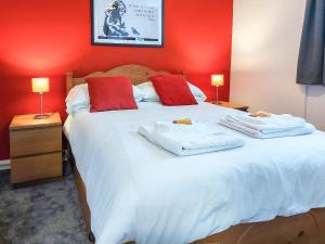 ボウネス・オン・ウィンダミアにあるBownessys Retreat - 26989のベッドルーム1室(赤い壁の白い大型ベッド1台付)