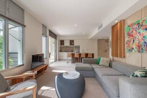 a living room with a couch and a table at 9309 Tranquil Viridian 2 Bedroom Luxury in Noosa Heads