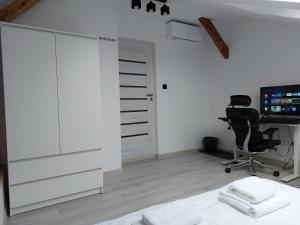a bedroom with a desk and a chair and a computer at Sleep In Center in Kraków