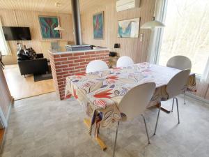 a dining room with a table and white chairs at Holiday Home Svanhild - 1-2km from the sea in Western Jutland by Interhome in Fanø