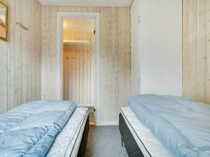 twee bedden in een kamer met houten wanden bij Holiday Home Patrice - 2km from the sea in Western Jutland by Interhome in Fanø