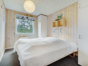 een slaapkamer met een groot wit bed en een raam bij Holiday Home Patrice - 2km from the sea in Western Jutland by Interhome in Fanø
