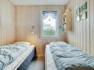 twee bedden in een kamer met een raam bij Holiday Home Patrice - 2km from the sea in Western Jutland by Interhome in Fanø