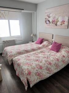 a bedroom with two beds with pink pillows at Tres Cruces Apartment in Las Navas del Marqués