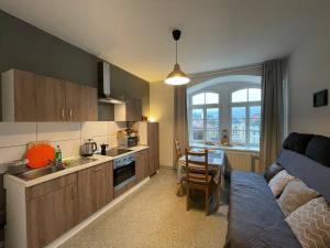 a kitchen and living room with a bed and a table at Bergblick Apartment Sächsische Schweiz in Sebnitz