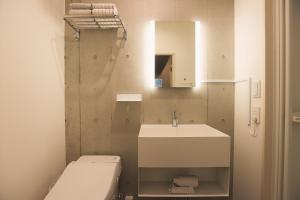 a bathroom with a toilet and a sink and a mirror at Hotel Tabiya ホテルたびや in Tokyo