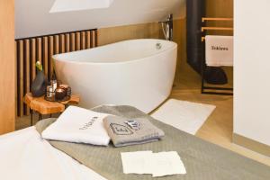 a bathroom with a bath tub and a table with towels at Enklawa - Apartamenty z balią w otoczeniu natury in Nowy Podleś