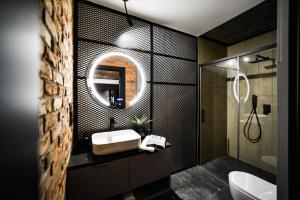 a bathroom with a sink and a mirror at Enklawa - Apartamenty z balią w otoczeniu natury in Nowy Podleś