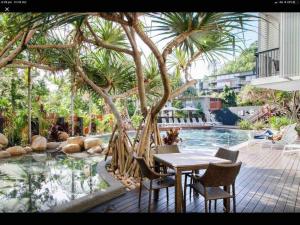 a patio with a table and chairs next to a pool at 7211 Lovely 2 Bedroom Viridian Noosa in Noosa Heads