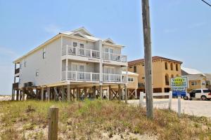 a house on the beach with a sign in front of it at Bonhomme Richard East in Gulf Shores