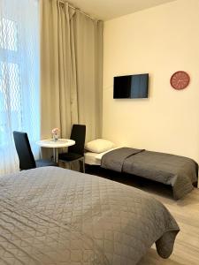 - une chambre avec 2 lits, une table et une télévision dans l'établissement Maria Apartment Liben, à Prague