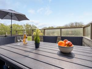 a bowl of fruit on a wooden table on a deck at Holiday Home Arona - 1-5km from the sea in Western Jutland by Interhome in Fanø