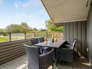 a table and chairs on the deck of a house at Holiday Home Arona - 1-5km from the sea in Western Jutland by Interhome in Fanø