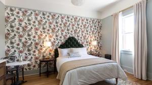 a bedroom with a large bed with a floral wallpaper at National Exchange Hotel in Nevada City