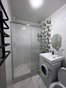 ein Bad mit einer Dusche und einer Waschmaschine in der Unterkunft 2-room apartment Centrium Residence in Bischkek