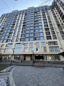 ein großes Gebäude mit einer Bank davor in der Unterkunft 2-room apartment Centrium Residence in Bischkek