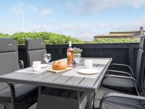 a table with a sandwich and wine glasses on a balcony at Holiday Home Kris - 200m from the sea in Western Jutland by Interhome in Fanø