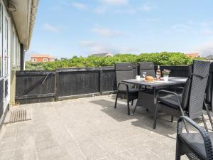 a patio with a table and chairs on a balcony at Holiday Home Kris - 200m from the sea in Western Jutland by Interhome in Fanø