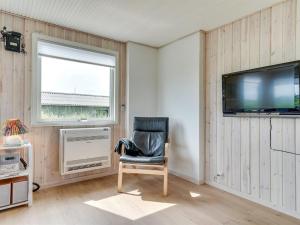 a room with a chair and a tv and a window at Holiday Home Kris - 200m from the sea in Western Jutland by Interhome in Fanø