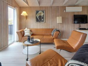 a living room with a couch and a table at Holiday Home Casandra - 600m from the sea in Western Jutland by Interhome in Fanø