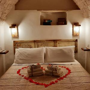a bedroom with a bed with two towels and a heart at Lumè in Putignano
