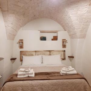 a bedroom with a bed with two towels on it at Lumè in Putignano
