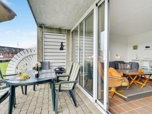 un patio con tavolo e sedie sul balcone. di Apartment Iliane - 100m from the sea in Western Jutland by Interhome a Fanø