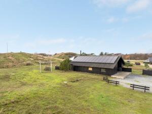 a building in a field with a soccer ball at Holiday Home Emund - 900m from the sea in Western Jutland by Interhome in Fanø