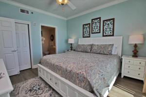 1 dormitorio con 1 cama grande y paredes azules en Crystal Shores West 1007 en Gulf Shores
