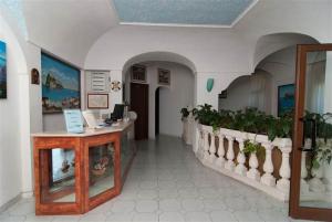 un hall doté d'un comptoir avec des plantes en pot dans l'établissement Hotel La Ninfea, à Ischia
