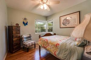 een slaapkamer met een bed, een stoel en een raam bij Bluebird Bungalow in Jacksonville