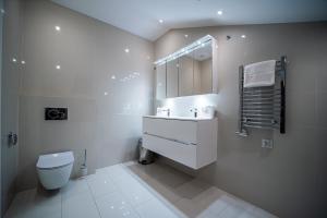 a white bathroom with a toilet and a sink at Apartamenty Rynek 7 by Hotel Żywiecki**** in Żywiec